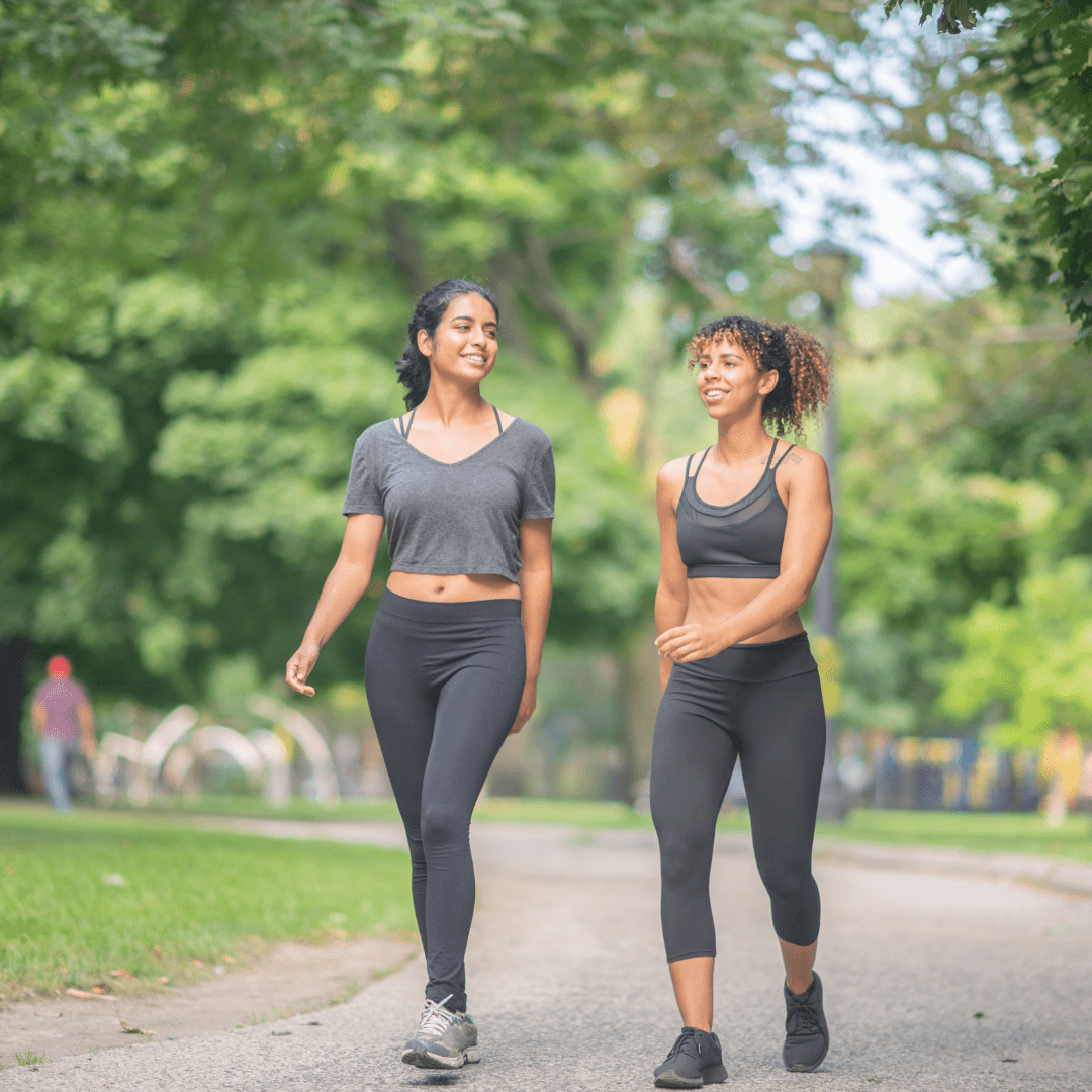 A pair of busy women doing a guided walking workout outside. 